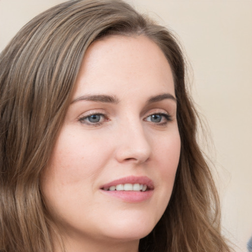 Joyful white young-adult female with long  brown hair and green eyes