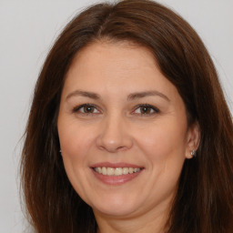 Joyful white adult female with long  brown hair and brown eyes