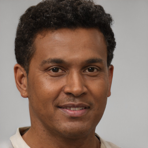 Joyful black young-adult male with short  brown hair and brown eyes