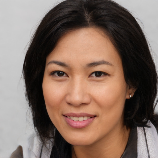 Joyful asian young-adult female with long  brown hair and brown eyes