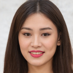 Joyful asian young-adult female with long  brown hair and brown eyes