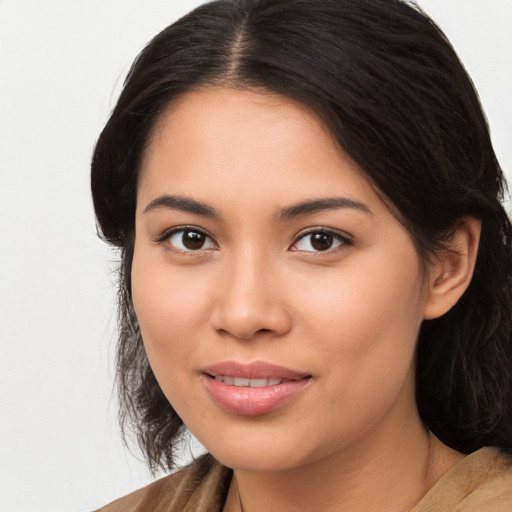 Joyful latino young-adult female with long  brown hair and brown eyes