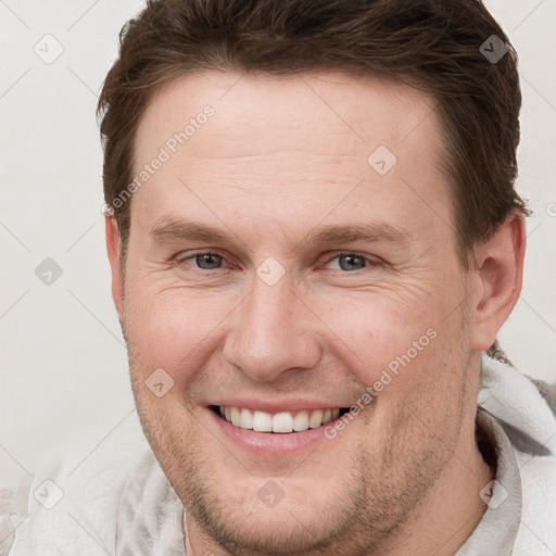 Joyful white adult male with short  brown hair and grey eyes