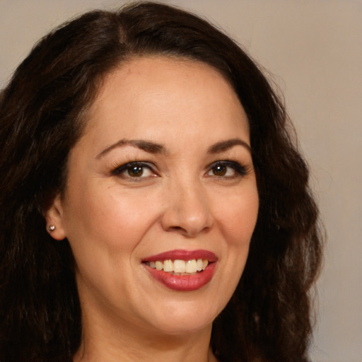 Joyful white adult female with long  brown hair and brown eyes