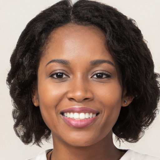 Joyful black young-adult female with medium  brown hair and brown eyes