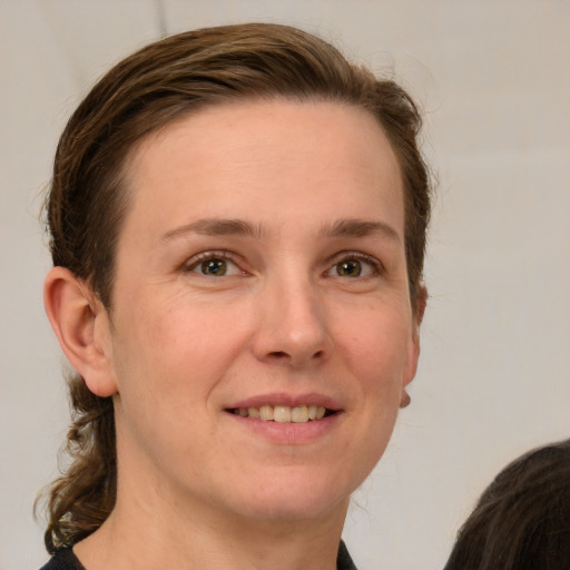 Joyful white young-adult female with long  brown hair and grey eyes