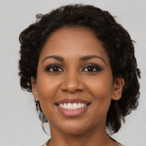 Joyful black young-adult female with long  brown hair and brown eyes