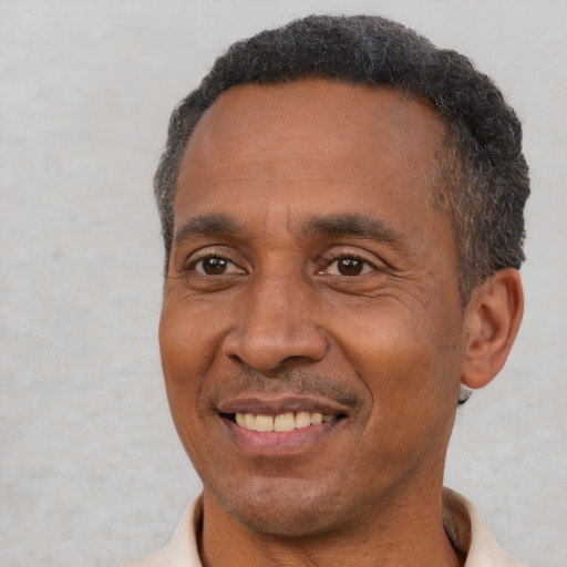 Joyful black adult male with short  black hair and brown eyes