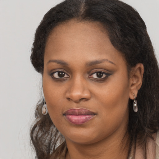 Joyful black young-adult female with long  brown hair and brown eyes