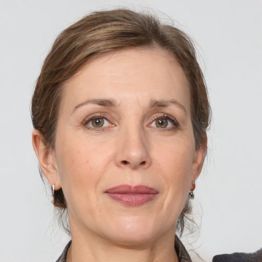 Joyful white adult female with medium  brown hair and grey eyes