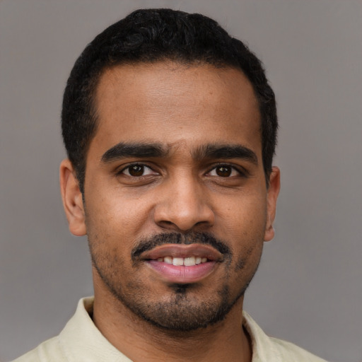 Joyful black young-adult male with short  black hair and brown eyes