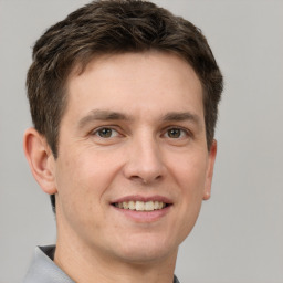 Joyful white adult male with short  brown hair and grey eyes