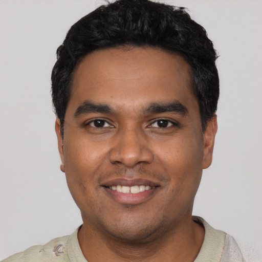 Joyful latino young-adult male with short  black hair and brown eyes