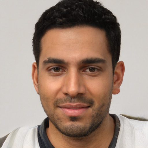 Joyful latino young-adult male with short  black hair and brown eyes