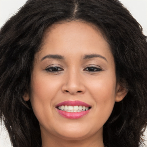 Joyful latino young-adult female with long  brown hair and brown eyes