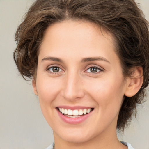 Joyful white young-adult female with medium  brown hair and green eyes