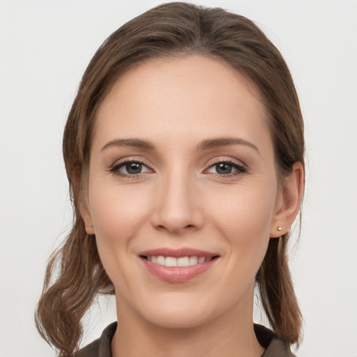 Joyful white young-adult female with long  brown hair and brown eyes