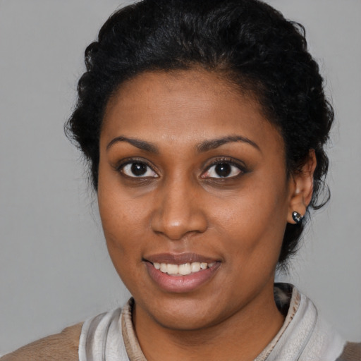 Joyful black young-adult female with short  brown hair and brown eyes