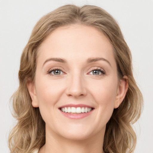 Joyful white young-adult female with long  brown hair and green eyes