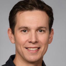 Joyful white adult male with short  brown hair and grey eyes