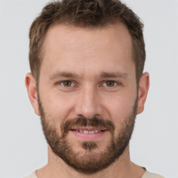 Joyful white young-adult male with short  brown hair and grey eyes