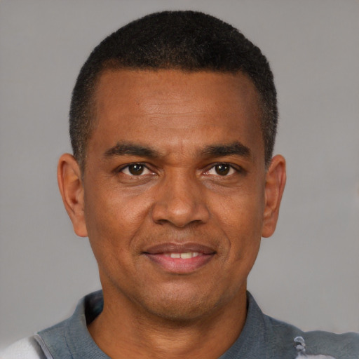 Joyful black adult male with short  black hair and brown eyes