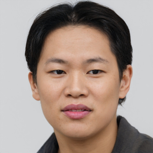 Joyful asian young-adult male with short  brown hair and brown eyes