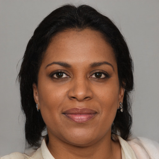 Joyful black adult female with medium  brown hair and brown eyes