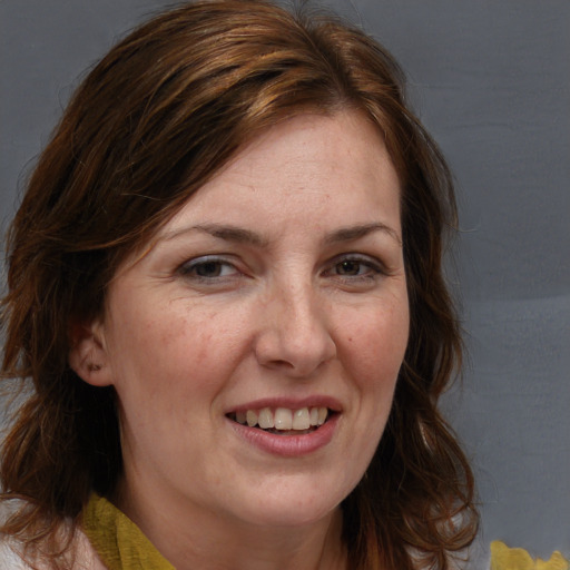 Joyful white adult female with medium  brown hair and brown eyes