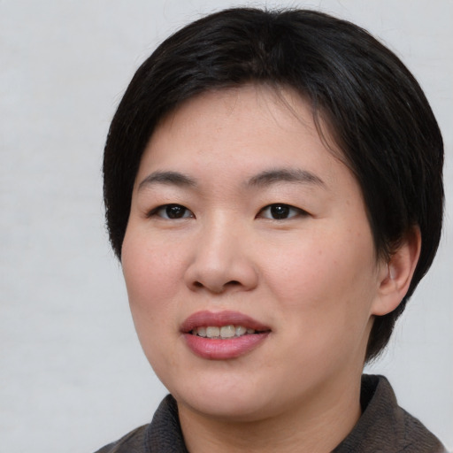 Joyful asian young-adult female with short  black hair and brown eyes