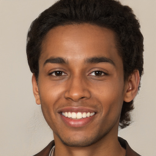 Joyful black young-adult male with short  brown hair and brown eyes