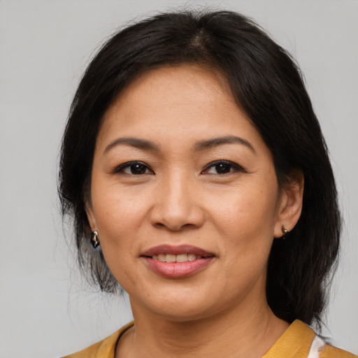 Joyful asian adult female with medium  brown hair and brown eyes