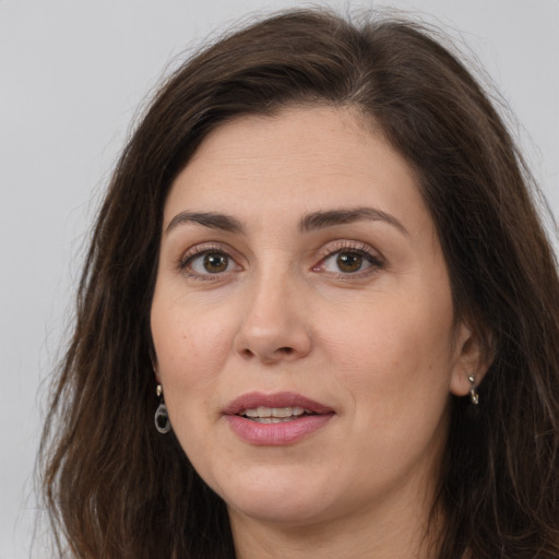 Joyful white adult female with long  brown hair and brown eyes