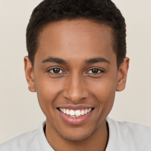 Joyful black young-adult male with short  brown hair and brown eyes