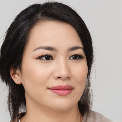Joyful asian young-adult female with medium  brown hair and brown eyes