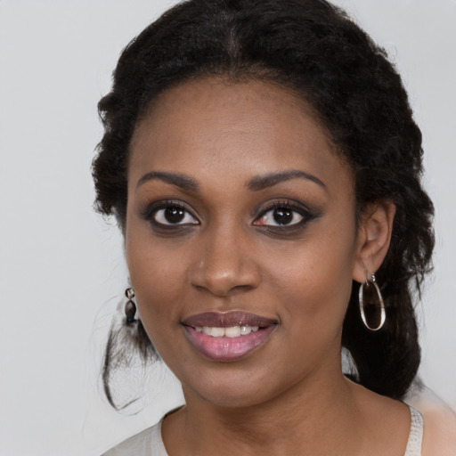 Joyful black young-adult female with long  black hair and brown eyes