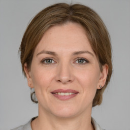 Joyful white adult female with medium  brown hair and grey eyes