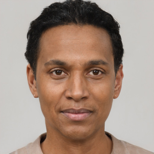 Joyful black young-adult male with short  black hair and brown eyes