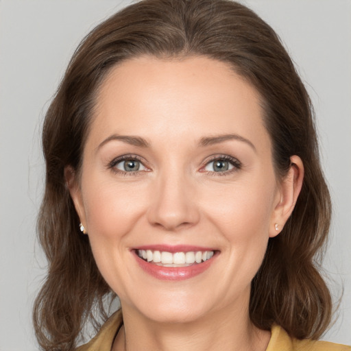 Joyful white young-adult female with medium  brown hair and grey eyes