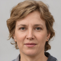 Joyful white adult female with medium  brown hair and grey eyes