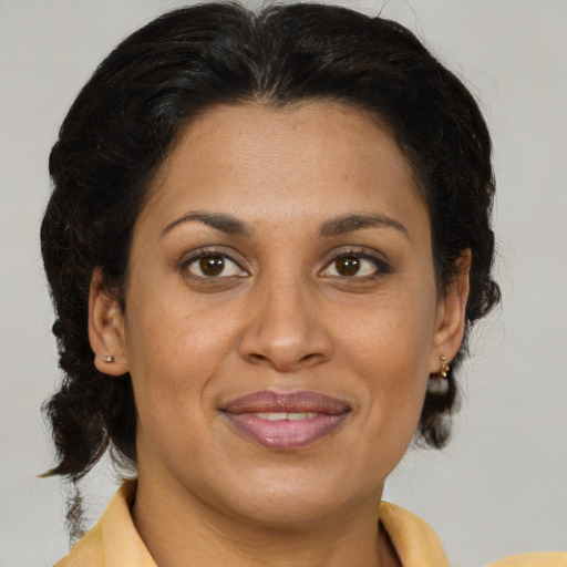 Joyful latino adult female with medium  brown hair and brown eyes