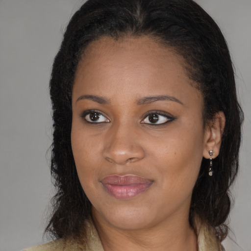 Joyful black young-adult female with long  brown hair and brown eyes