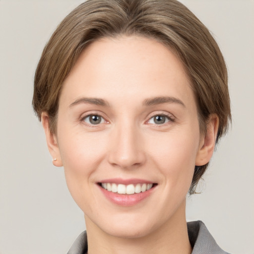 Joyful white young-adult female with medium  brown hair and grey eyes