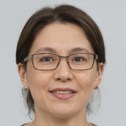 Joyful white adult female with medium  brown hair and grey eyes