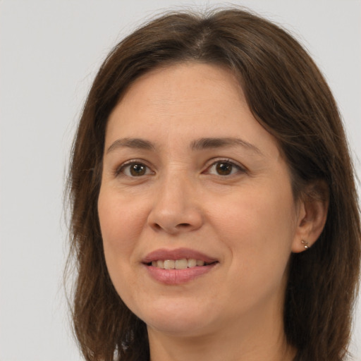 Joyful white adult female with long  brown hair and brown eyes