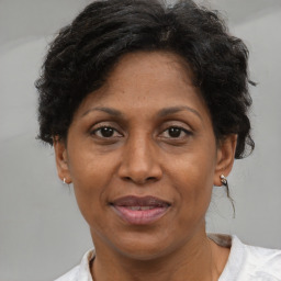 Joyful black adult female with short  brown hair and brown eyes