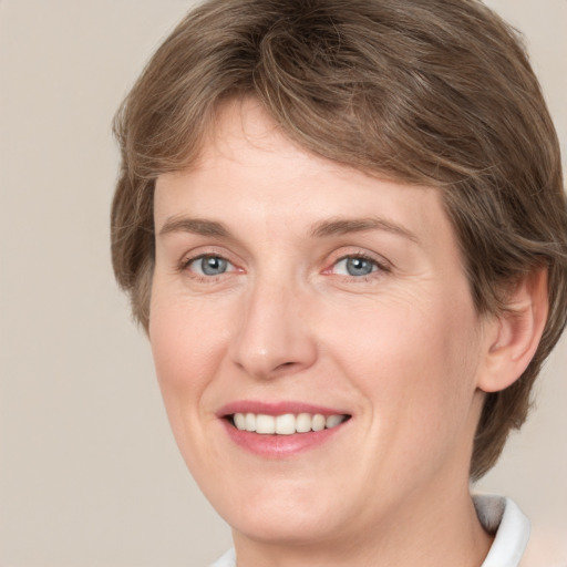 Joyful white adult female with medium  brown hair and grey eyes