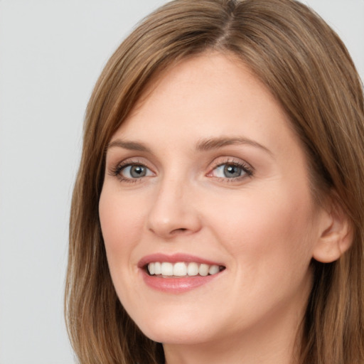 Joyful white young-adult female with long  brown hair and grey eyes