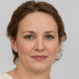 Joyful white adult female with medium  brown hair and green eyes