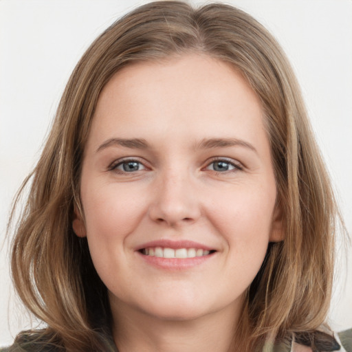 Joyful white young-adult female with medium  brown hair and grey eyes